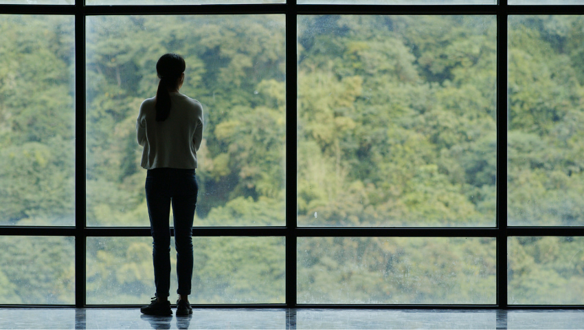 Woman standing before big window
